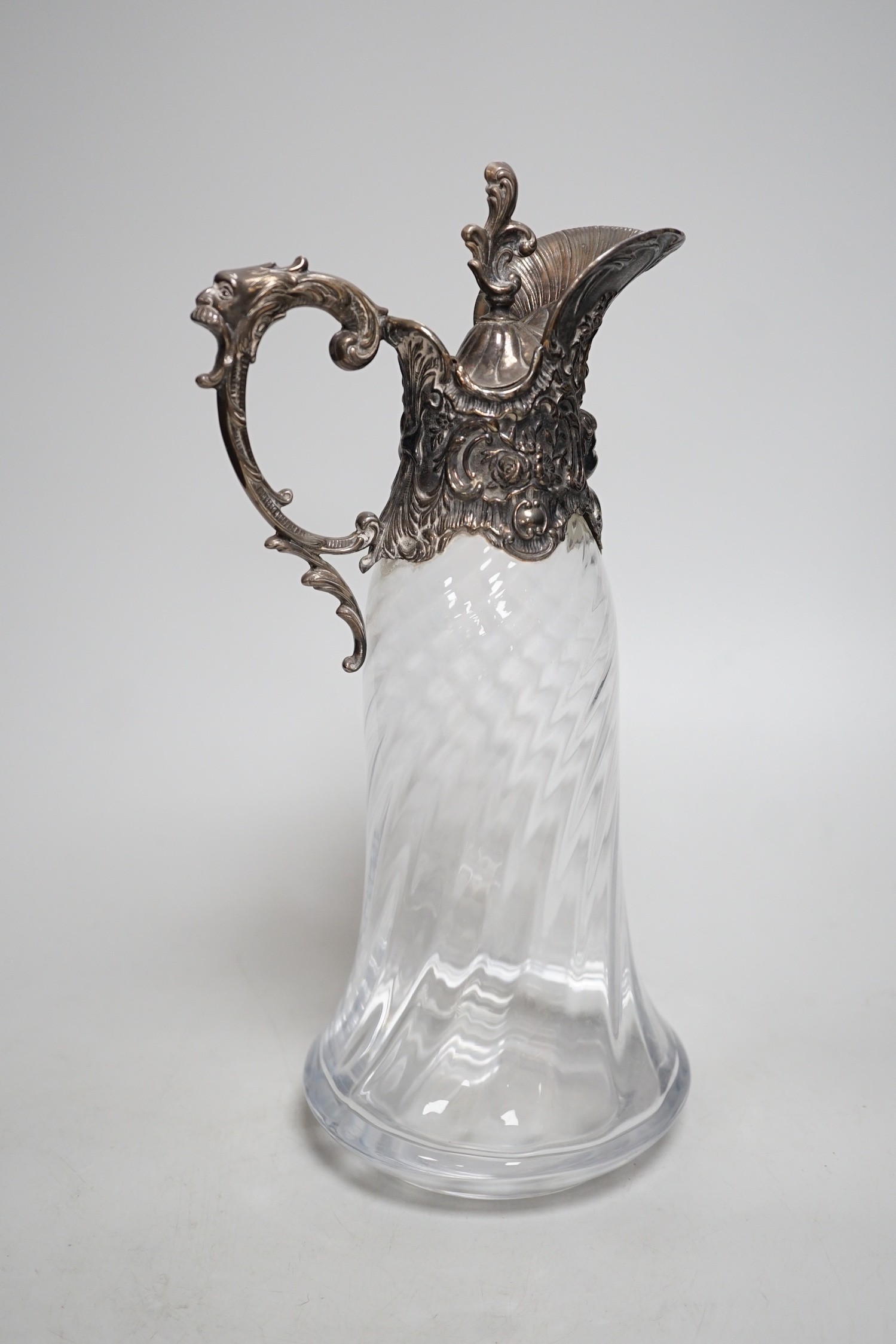 A Victorian rococo style electroplate mounted glass claret jug. 33cm tall